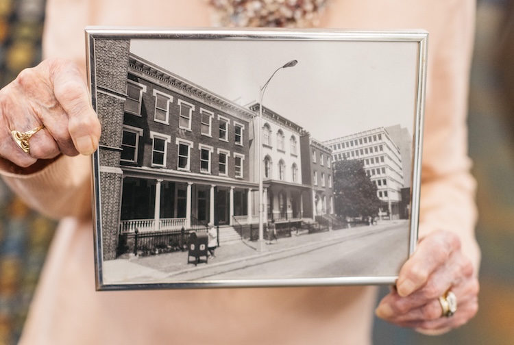 Older woman holding a photo of an old building