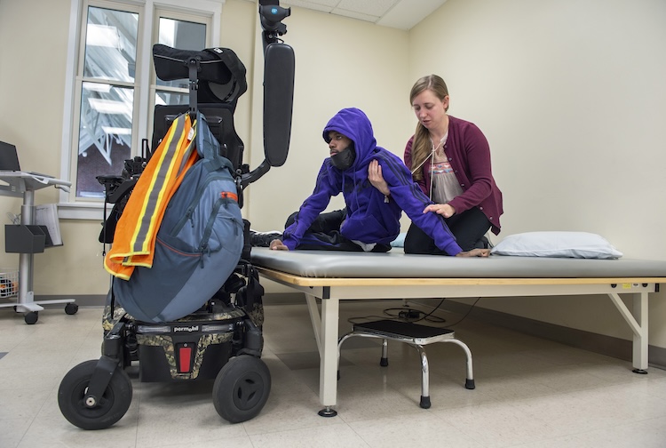 Physical therapist works with patient who is paralyzed during a session