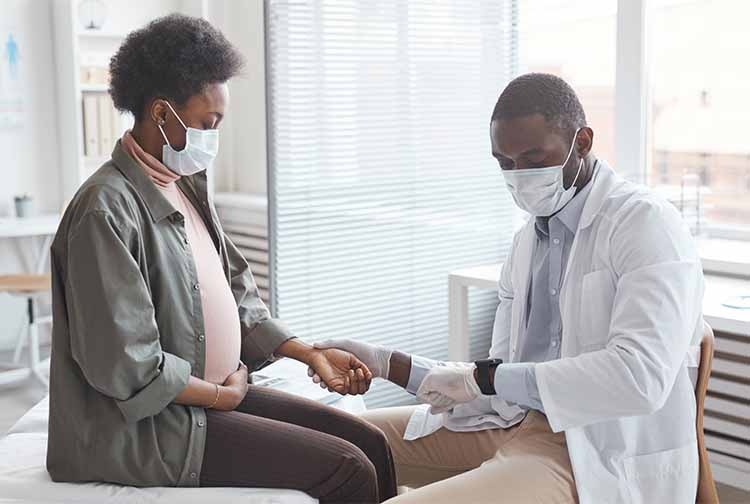 Black pregnant woman with doctor
