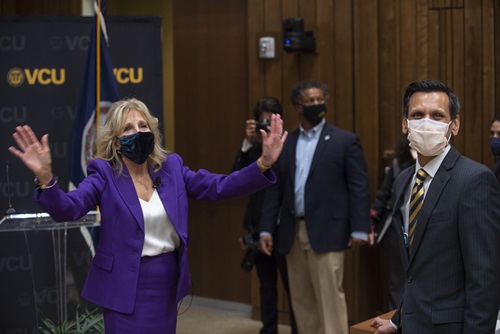 First lady Jill Biden, Ed.D., bids farewell to the audience. At right is VCU President Michael Rao, Ph.D. In the background (center) is Robert Winn, M.D., director of Massey Cancer Center. (Kevin Morley, University Marketing)