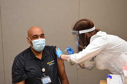 Stacy Davis vaccinates Curtis Poole of Wake Forest, North Carolina. Curtis is the Director of Food and Nutrition Services at VCU Health CMH.