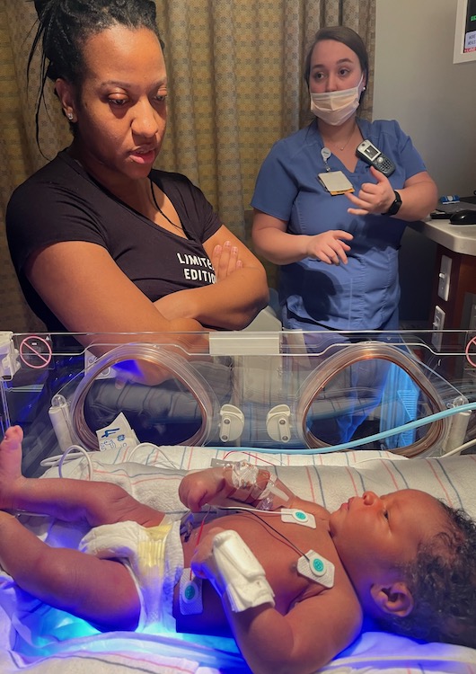 Concerned woman standing next to her baby in the NICU.