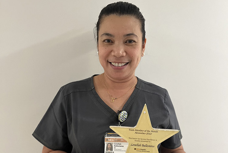 a nurse in scrubs poses with a star award
