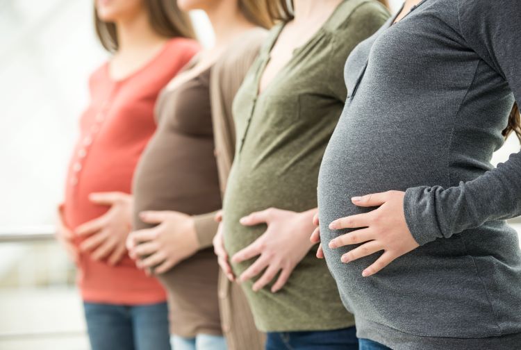 Four pregnant women standing together