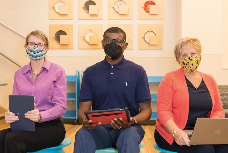 Three people sit on a couch with masks on. they work in with Richmond Health and Wellness program.