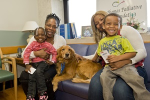 a family is pictured in a hospital room with their dog