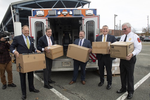 Dignitaries, including U.S. Senator Mark Warner (2nd from the left), load medical supplies onto Unit 85 before it departs for Ukraine