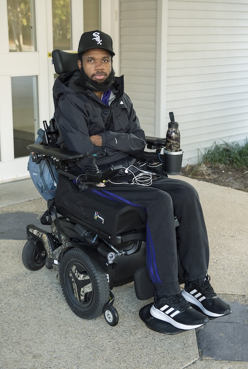 A man sitting in a wheelchair smiling at the camera