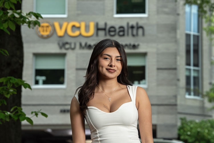 woman in white shirt in front of VCU Health