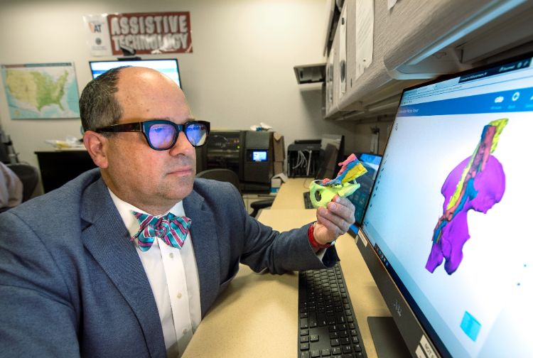 Michael Amendola, M.D., reviews a 3D print of a patient's anatomy that was created as part of a fellowship he oversees at the VCU School of Medicine.