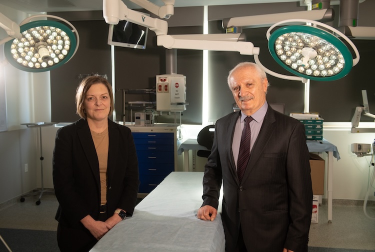 Two people in suits standing in a lab.