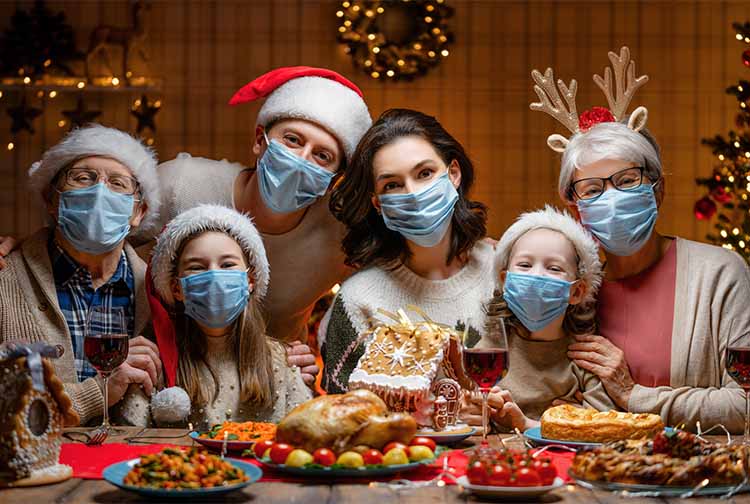 Portrait of family wearing Santa hats and face masks at dinner table