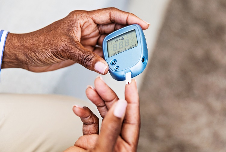 Image of hands holding a blue glucose monitor