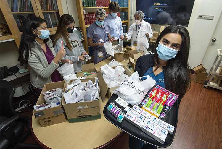 Nadia Abdul-Ghafoor, far right, with a dental supply kit. (Kevin Morley, University Marketing)