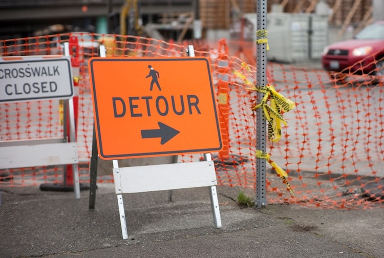 Orange detour sign in a construction zone.