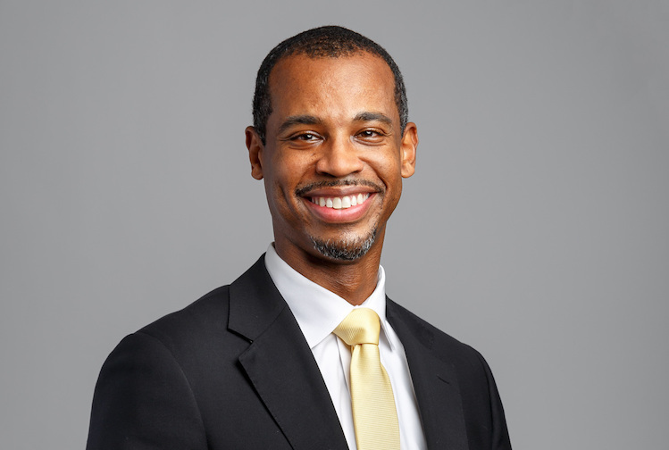 Man smiling in a suit for a professional photo