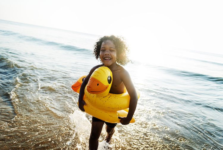 Cute toddler with duck tube by the water