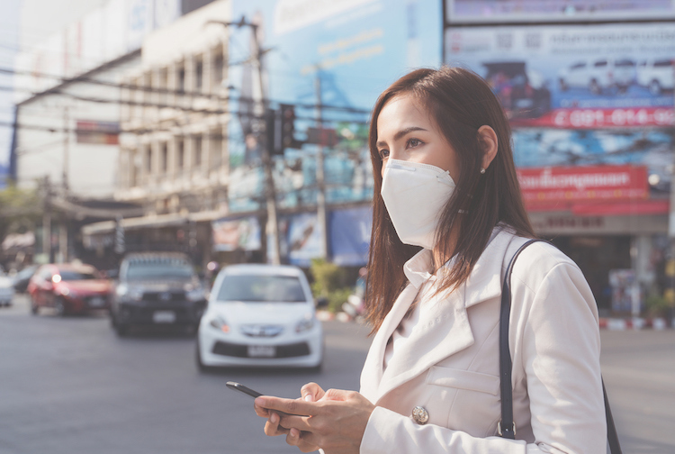 Woman wears a facemask because of bad air quality