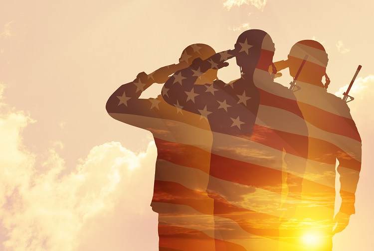 Three soldiers saluting behind American flag