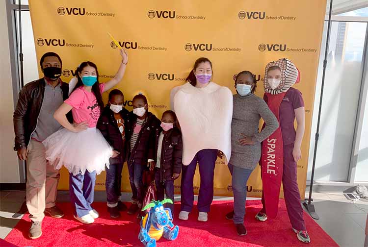 Group of children posing in dental costumes, like a toothbrush and a molar.