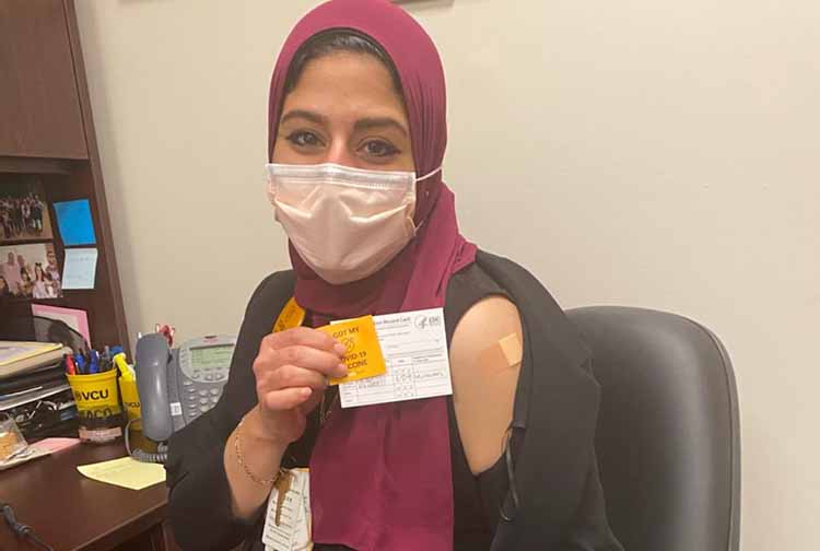 Heba Abbassy  wearing a headscarf and face mask at her desk