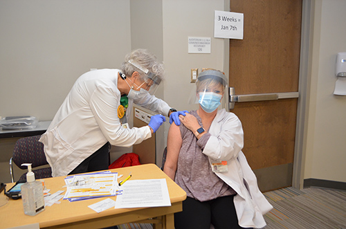 Patty Mayer vaccinates Jackie Daniel from Lunenburg County.