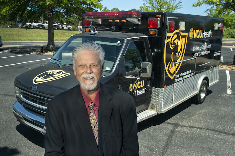James Gould standing outside in front of a VCU branded ambulance