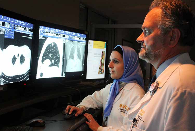Mark Parker, M.D., FACR, director of the Early Detection Lung Cancer Screening Program at Massey, and VCU Health radiologist Leila Rezai Gharai, MD, reviewing a patient's lung CT scan. 