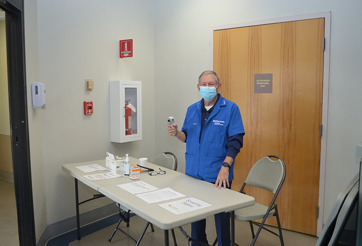 Tom Watters checks temperatures at the VCU Health CMH vaccine clinic.
