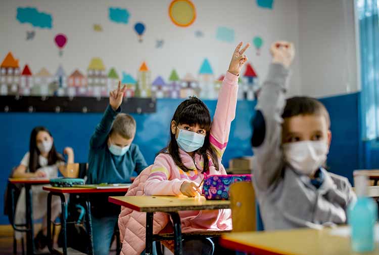 School children in classroom wearing masks