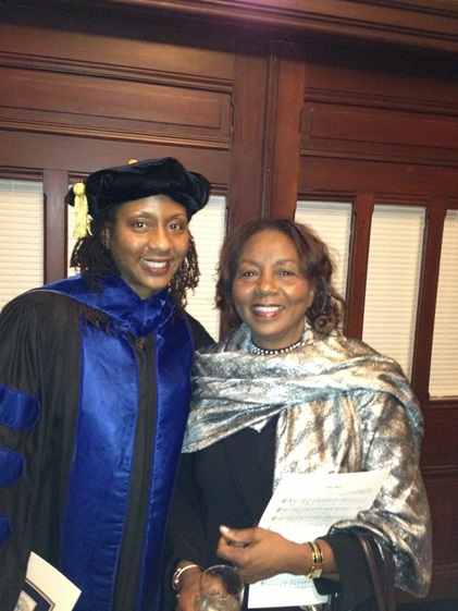 Vanessa Sheppard, wearing a cap and gown, stands with her mother Winifred Philips at a university convocation.