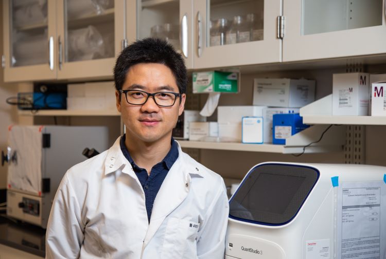 Dr. Guizhi "Julian" Zhu stands in a laboratory