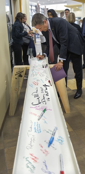 MCV Foundation board of trustees chair Harry Thalhimer signs the School of Allied Health Professions beam on Monday morning. 