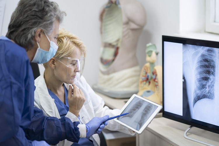 Two doctors examining a chest x-ray on a tablet