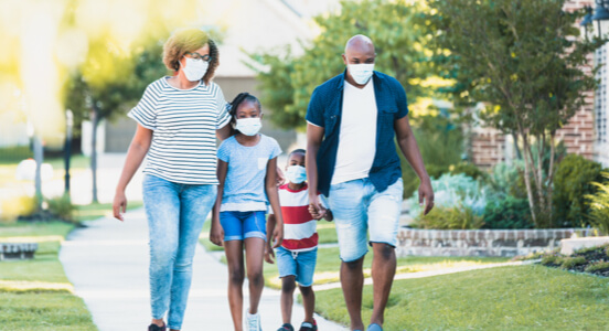 Parents and children walking together while wearing masks