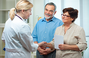 Photograph of two adults talking with a healthcare provider.