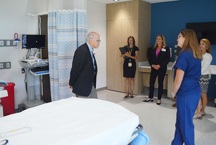A group of visitors tour a hospital room.