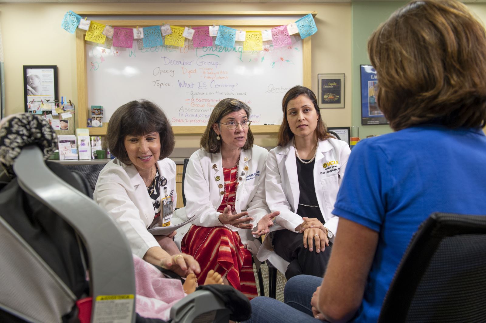 Three women talk and lead a clinic.