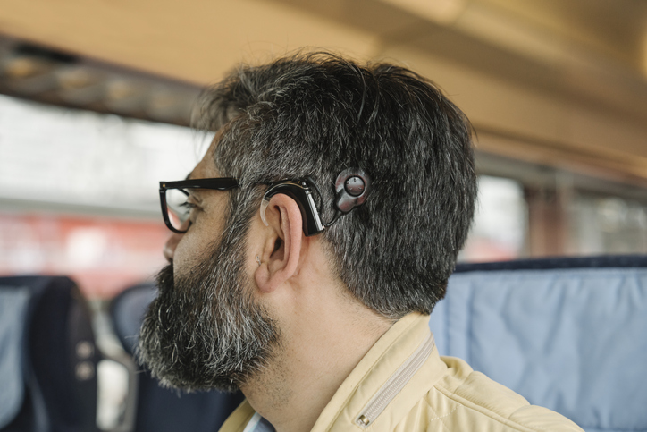 Profile of a man with cochlear implant in a train