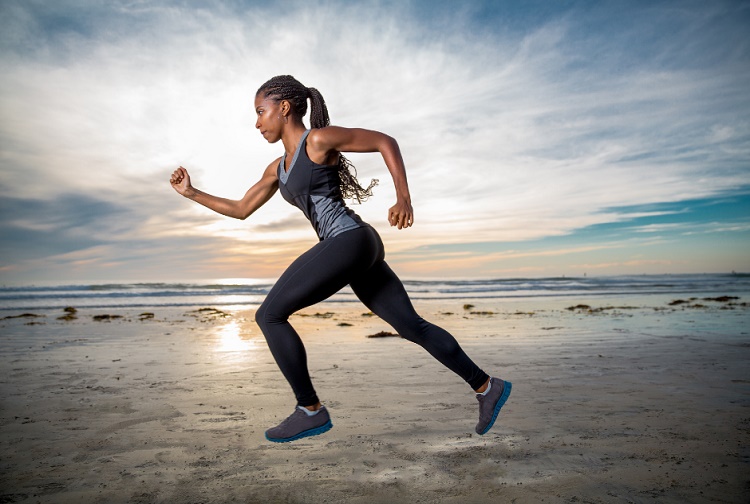 African-American woman running along a beach