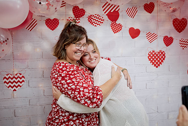 Two people hugging at a Pauley Heart Center event.