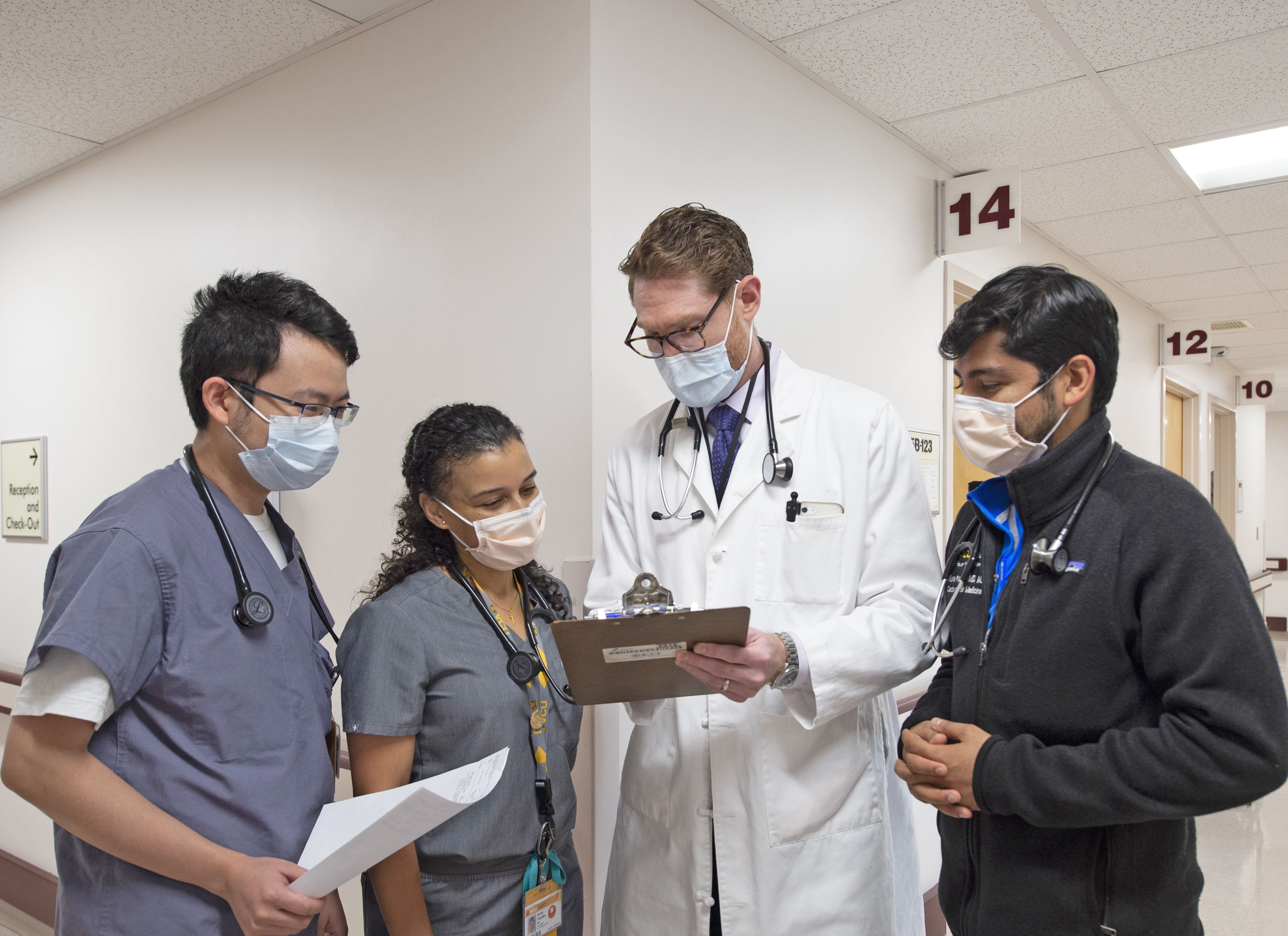 Jonah Pozen, M.D., VCU Health Pauley Heart Center assistant professor of medicine and Central Virginia VA Health Care System staff cardiologist, speaks with fellows Kunal Kapoor, M.D., Anna Tomdio, M.D., and Pengyang Li, M.D., as they review patients in the VA Cardiology subspeciality clinic.