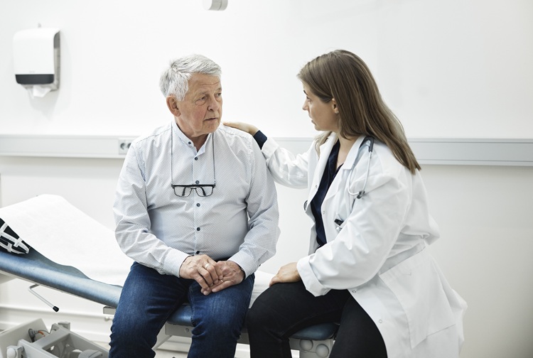 A patient and doctor sit together in an exam room.