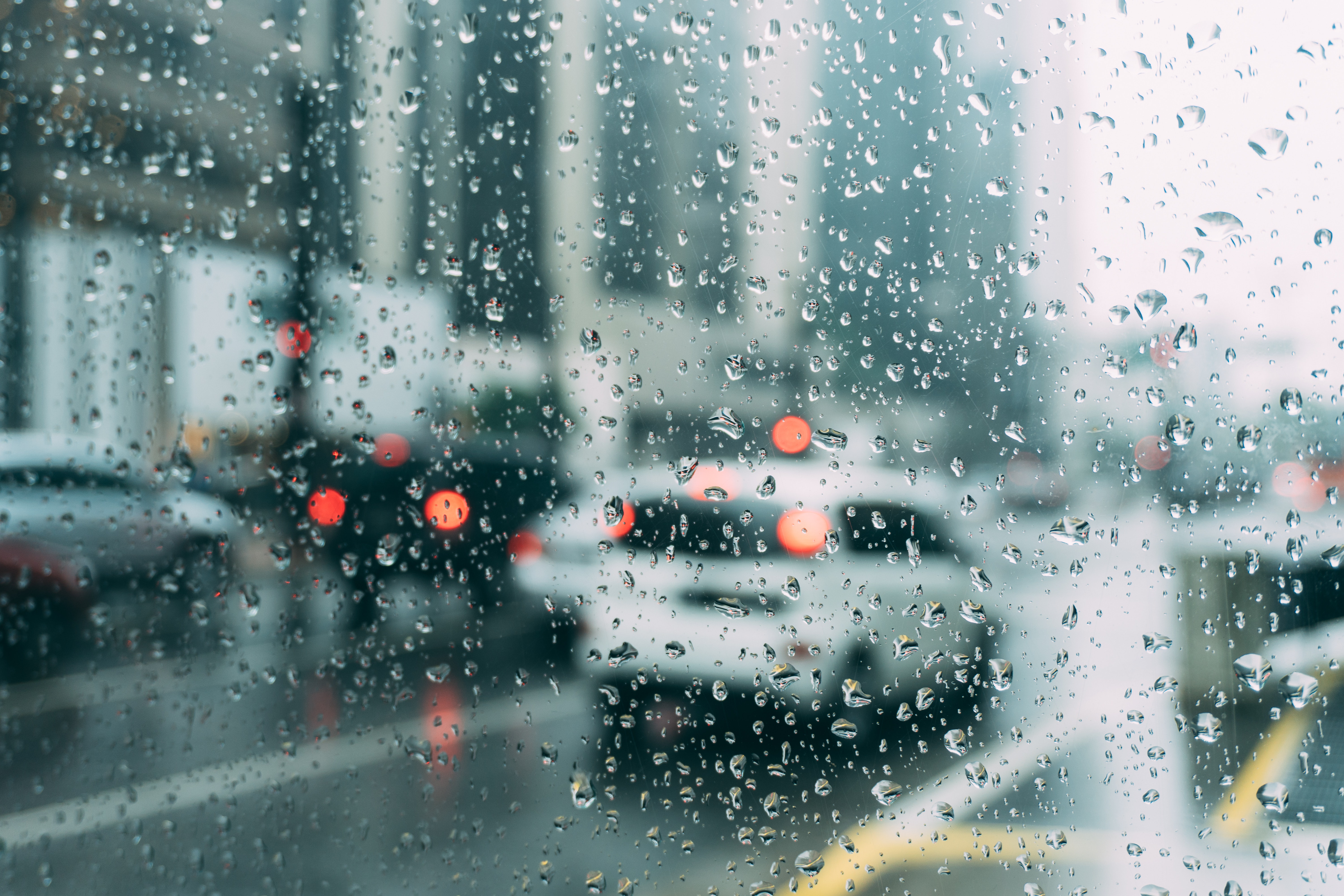A city street viewed through a window with raindrops.