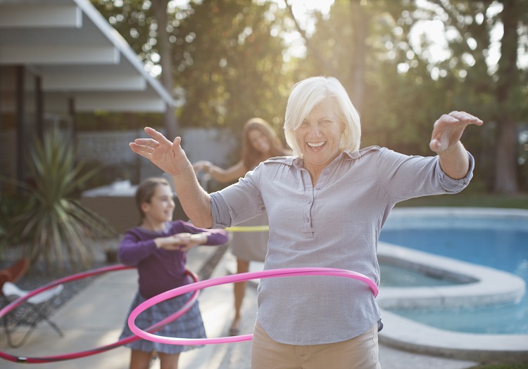 A woman smiling while hoop dancing