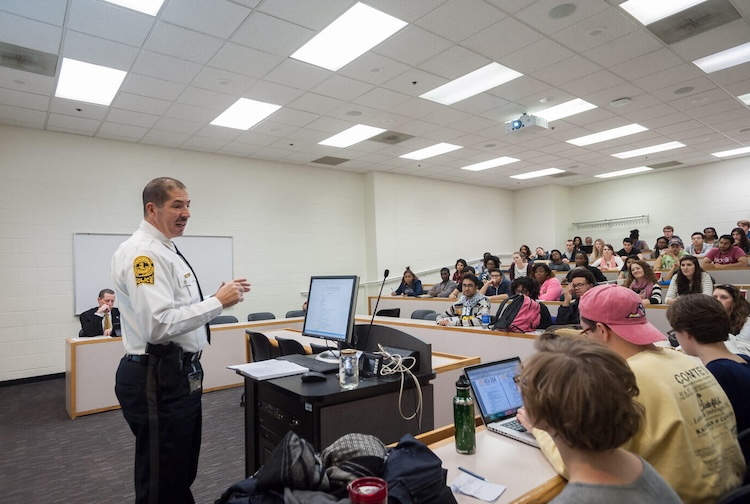 Man speaking to crowd in classroom