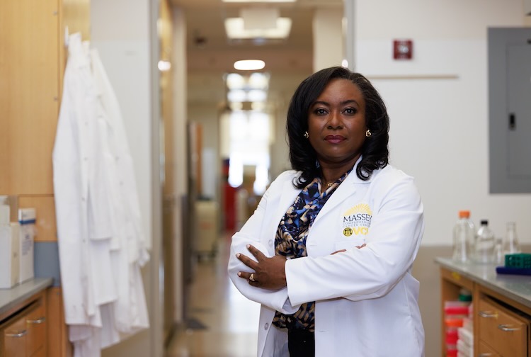 Dr. Monica Baskin standing with arms folded in a white in a lab.
