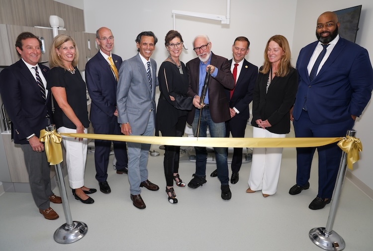 University and state officials join the Dr. Wood and his wife, Karen Wood, at the ribbon cutting of the clinic.