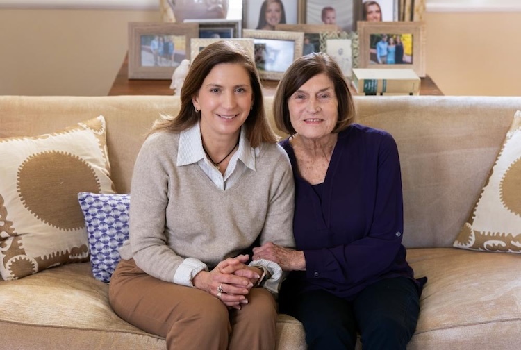 daughter and mother sit on couch