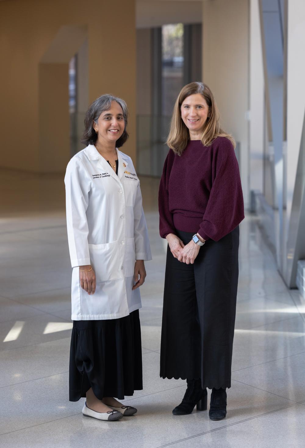 woman in white doctor’s coat stands next to patient